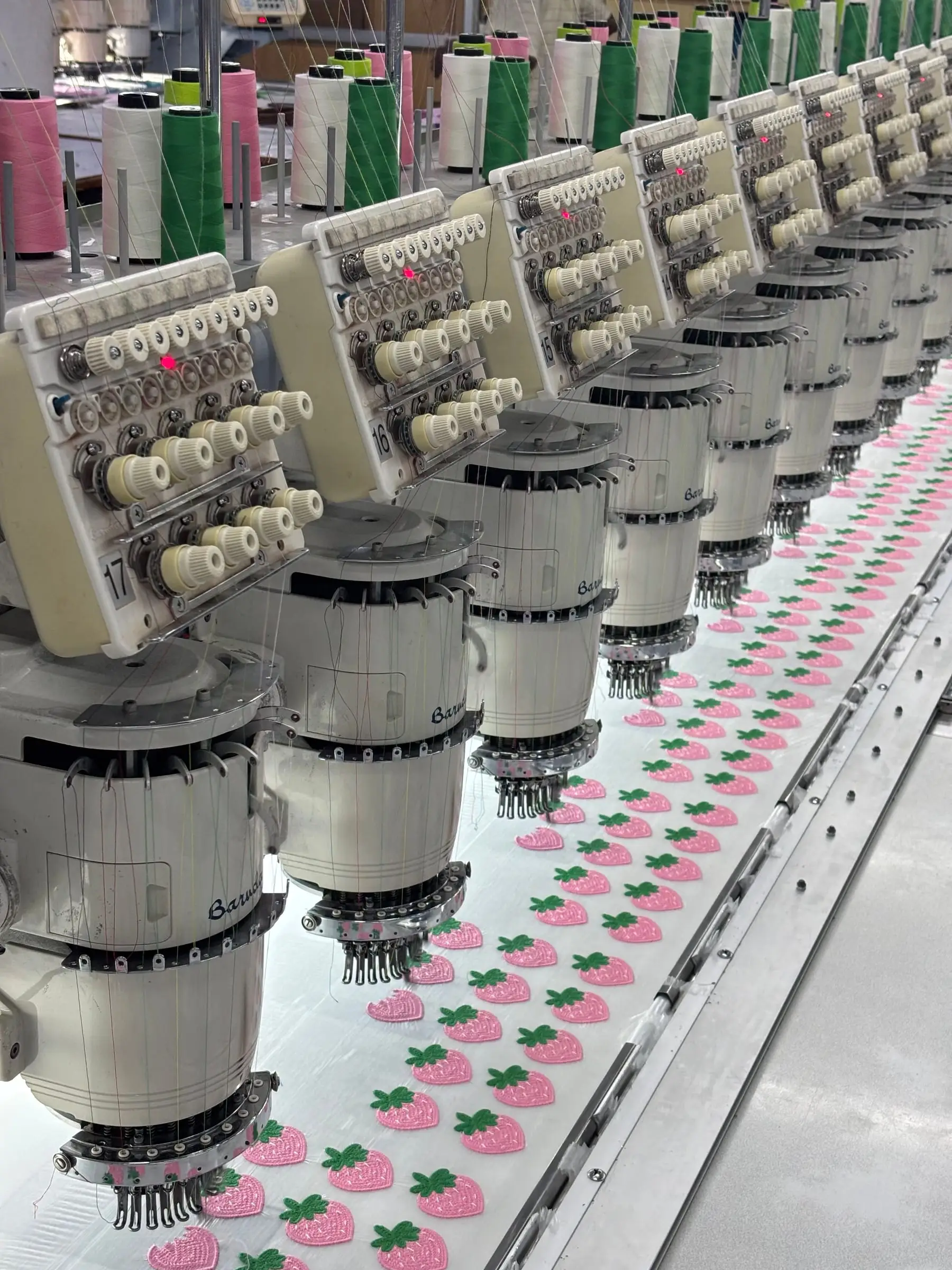 A bank of embroidery heads working in step across the width of the frame.